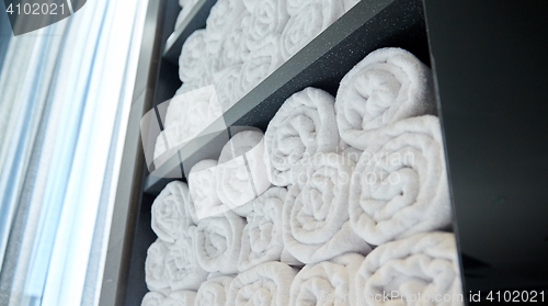 Image of rolled white bath towels at hotel spa