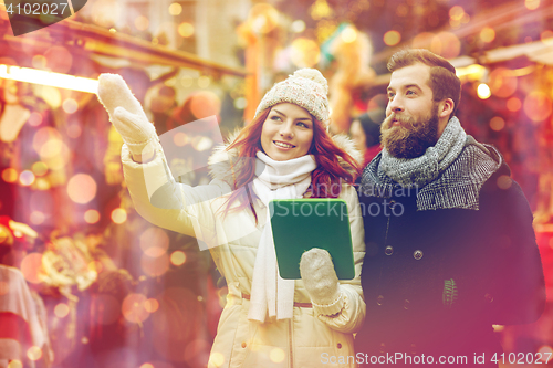 Image of happy couple walking with tablet pc in old town