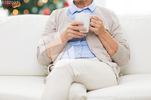 Image of close up of senior woman with tea cup at christmas
