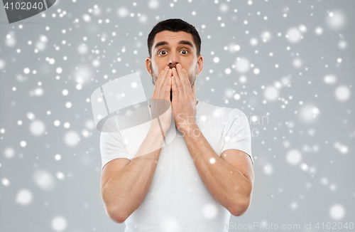 Image of scared man in white t-shirt over snow background