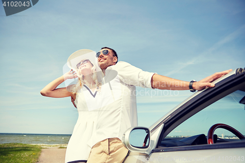 Image of happy couple hugging near cabriolet car at sea