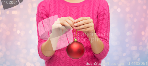 Image of close up of woman in sweater with christmas ball