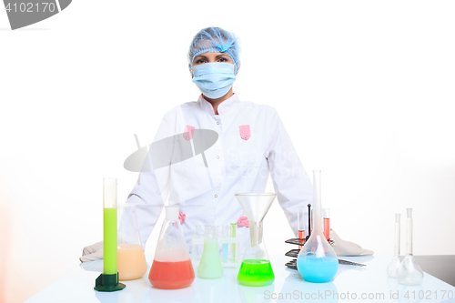 Image of Woman chemist and chemicals in flasks