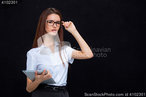 Image of The young business woman with tablet on black background