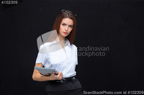 Image of The young business woman with tablet on black background