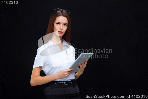 Image of The young business woman with tablet on black background