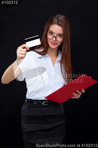 Image of The young business woman with credit card and tablet for notes on gray background