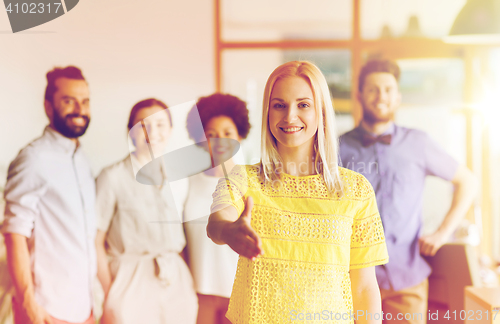 Image of woman making handshake over creative office team