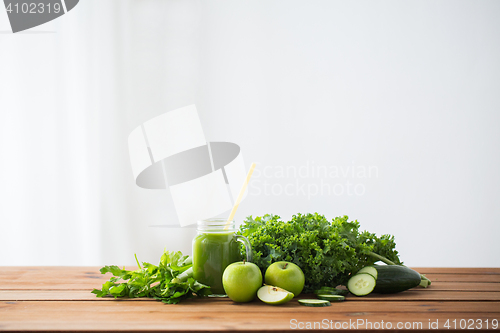 Image of close up of jug with green juice and vegetables