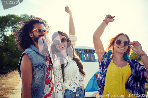 Image of happy young hippie friends dancing outdoors