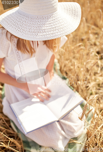 Image of close up of woman reading book on cereal field