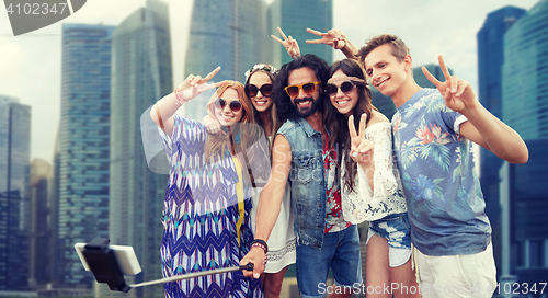 Image of hippie friends with smartphone selfie stick