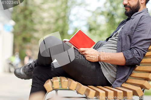 Image of close up of man writing to notebook on city street