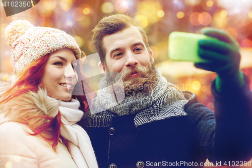 Image of couple taking selfie with smartphone in old town