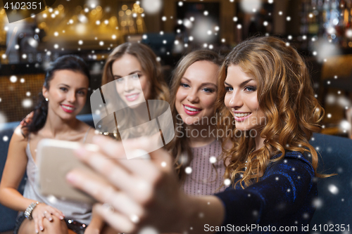 Image of women with smartphone taking selfie at night club