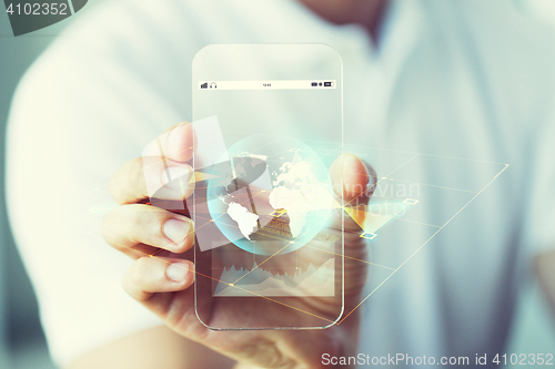 Image of close up of hand with earth globe on smartphone