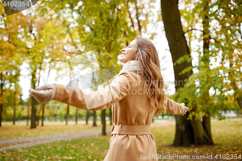 Image of beautiful happy young woman walking in autumn park