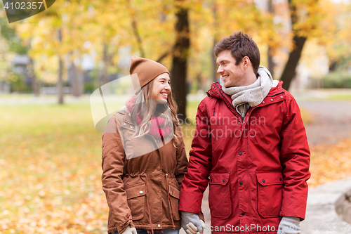 Image of happy young couple walking in autumn park