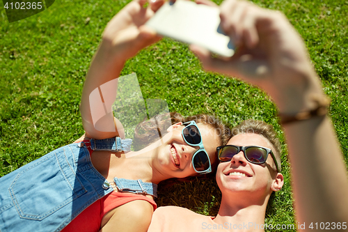 Image of happy couple taking selfie on smartphone at summer