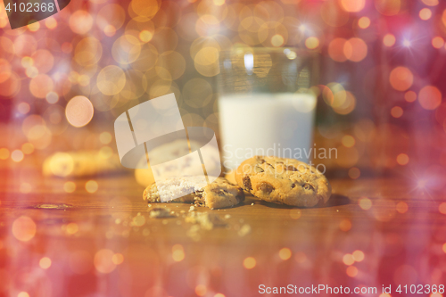 Image of close up of cookies and milk over christmas lights