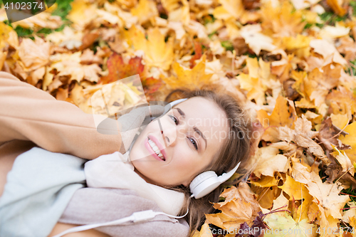 Image of woman with headphones listening to music in autumn