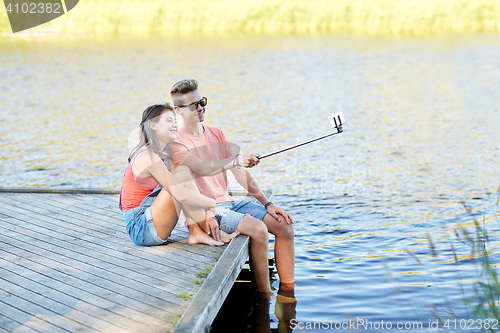 Image of happy teenage couple taking selfie on smartphone