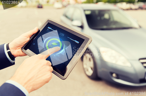 Image of close up of male hands with tablet pc and car