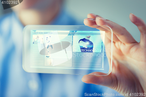Image of close up of woman with transparent smartphone
