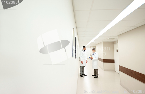 Image of male doctors with clipboard at hospital corridor