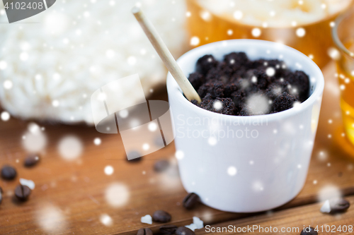 Image of homemade coffee scrub in cup on wooden table