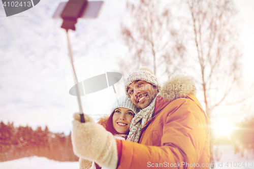 Image of happy couple taking selfie by smartphone in winter