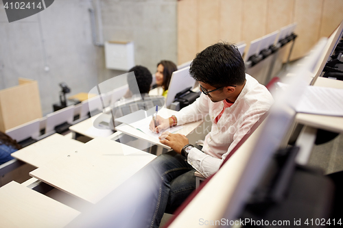 Image of group of students with notebooks in lecture hall