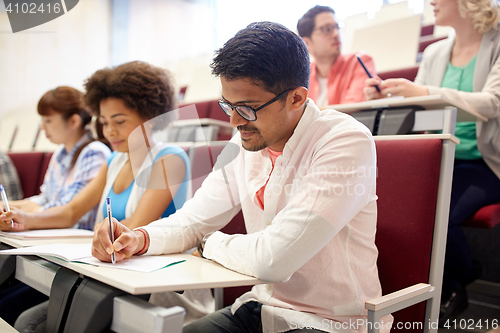 Image of group of students with notebooks in lecture hall