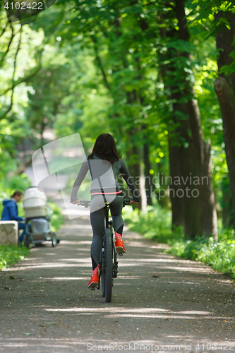 Image of cyclist woman riding a bicycle in park