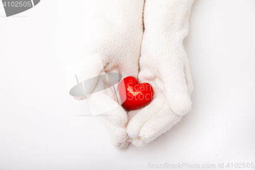 Image of Woman hands in white gloves holding heart symbol