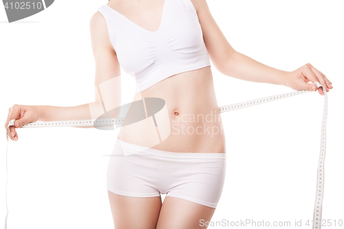 Image of Slimming woman measuring thigh with tape