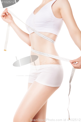 Image of Slimming woman measuring thigh with tape