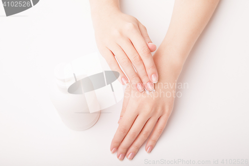 Image of Beautiful female hand applying cream
