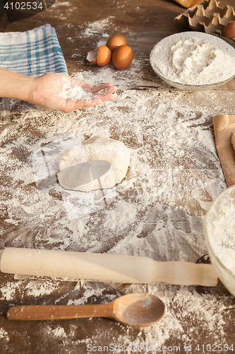 Image of Baker is holing flour on his palm.