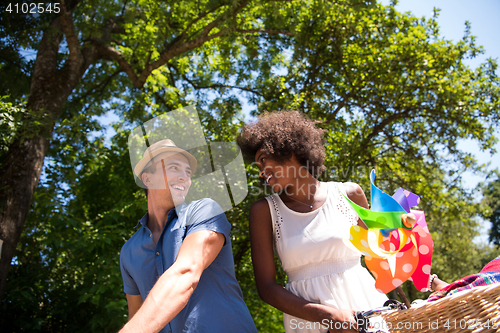 Image of Young multiethnic couple having a bike ride in nature