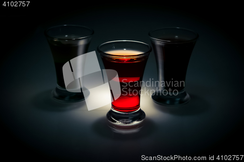 Image of red and tow shot glass on a dark background in the spot light