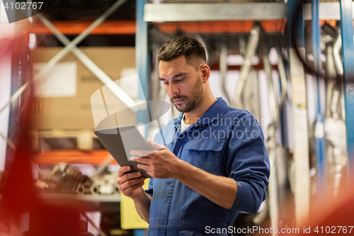 Image of auto mechanic or smith with tablet pc at workshop