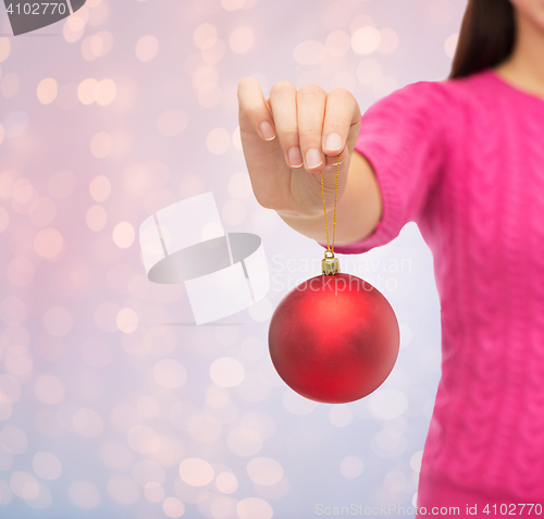 Image of close up of woman in sweater with christmas ball