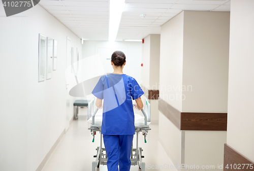 Image of nurse carrying hospital gurney to emergency room