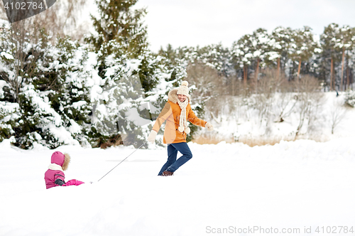 Image of happy father pulling sled with child in winter