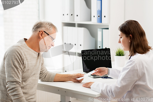 Image of senior man and doctor meeting at hospital