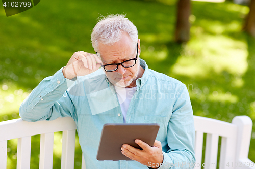 Image of senior man with tablet pc at summer park