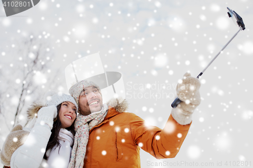 Image of happy couple taking selfie by smartphone in winter