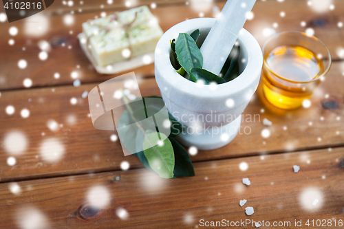 Image of mortar and pestle with leaves on wood