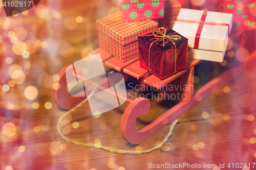 Image of close up of christmas gift boxes on wooden sleigh